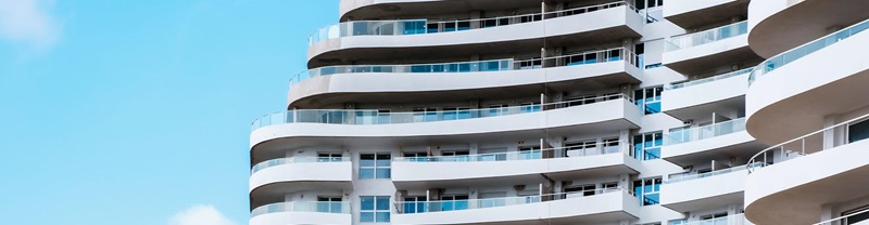 Detail of the large facade of a white building with terraces and balconies